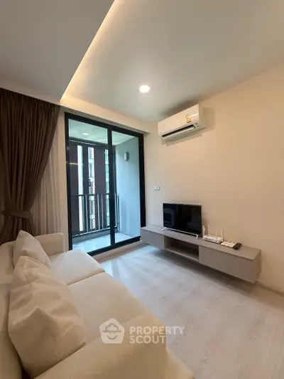 Modern living room with balcony access and sleek furniture in a stylish apartment.