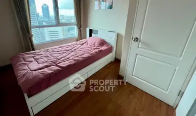 Cozy bedroom with city view, featuring a single bed and wooden flooring, perfect for urban living.