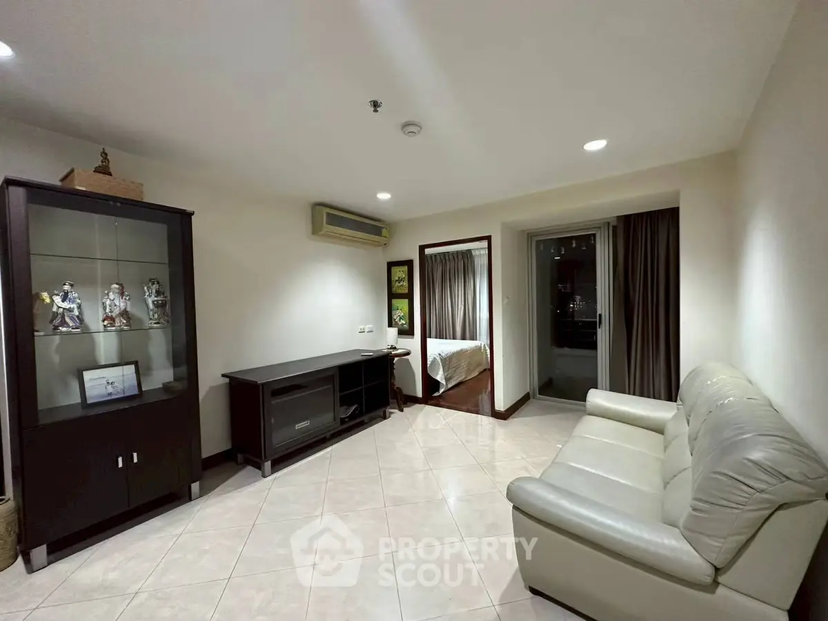 Spacious living room with modern decor and adjacent bedroom view