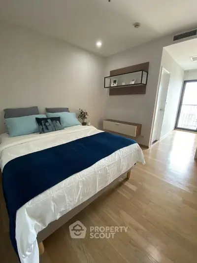 Modern bedroom with wooden flooring and stylish decor in a bright apartment
