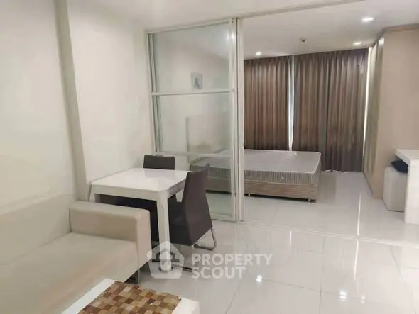 Modern studio apartment with sleek design and open layout, featuring a cozy dining area and comfortable sleeping space.