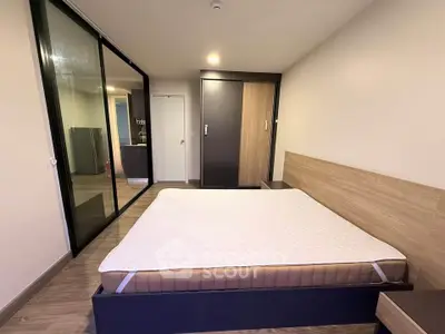 Modern bedroom with large bed and mirrored closet doors in stylish apartment.