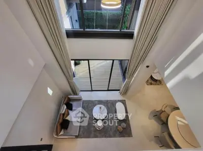 Stunning modern living room with high ceilings and elegant decor, featuring a spacious open layout and large windows.