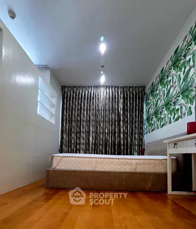 Spacious bedroom with modern decor and hardwood flooring