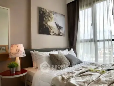 Cozy bedroom with elegant decor and large window offering natural light.