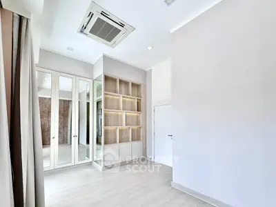 Spacious modern room with built-in shelves and mirrored closet doors