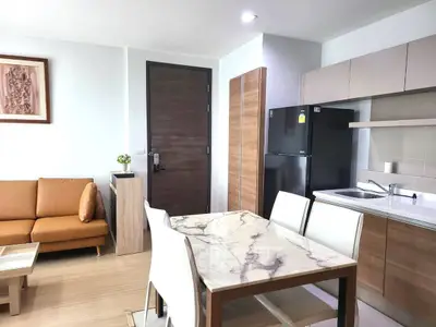 Modern open-layout kitchen and living room with marble dining table and sleek appliances.