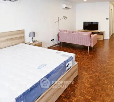 Spacious modern studio with parquet flooring, stylish furniture, and ample natural light.