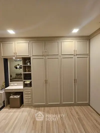 Elegant bedroom with built-in wardrobe and vanity in modern apartment