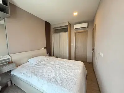 Modern bedroom with minimalist design, featuring a cozy bed, built-in wardrobe, and air conditioning unit.
