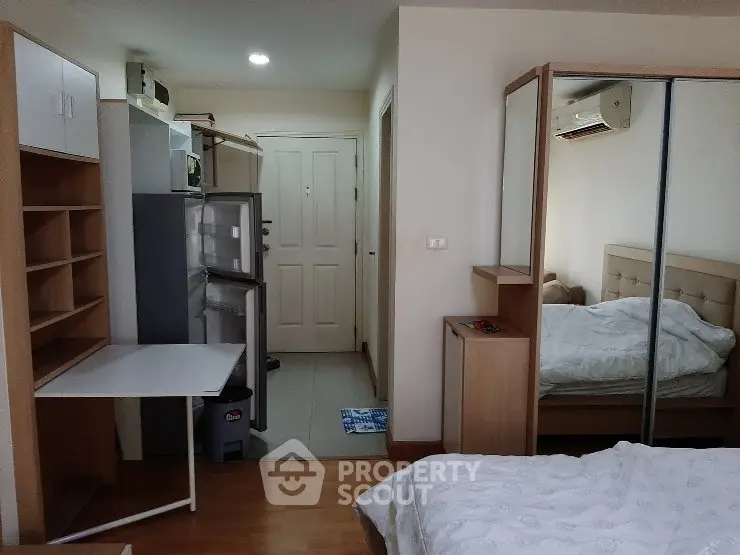 Cozy studio apartment with mirrored wardrobe and compact kitchen area