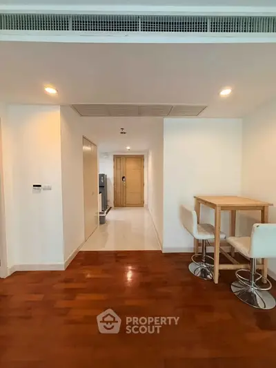 Spacious modern apartment interior with wooden flooring and stylish dining area.