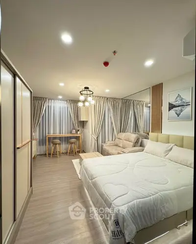 Modern bedroom with stylish decor, cozy seating area, and elegant lighting in a contemporary apartment.