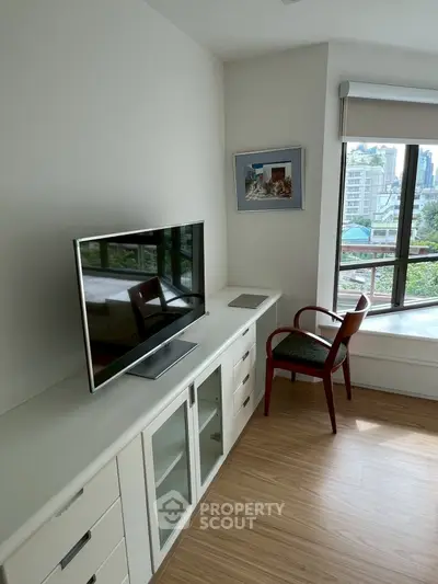 Bright living room with modern TV setup and city view
