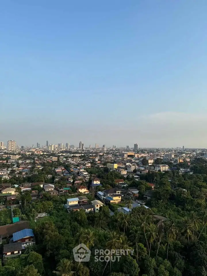 Stunning cityscape view from high-rise building showcasing urban skyline and lush greenery.