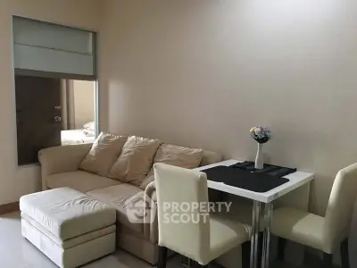 Cozy living room with beige sofa and dining table in modern apartment