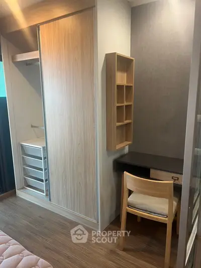 Modern bedroom with built-in wardrobe and cozy study nook, featuring wooden flooring and sleek design.