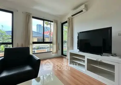 Bright and modern living room with large windows and sleek furniture, perfect for relaxation.