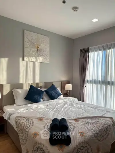 Bright and cozy bedroom with modern decor and large window for natural light.