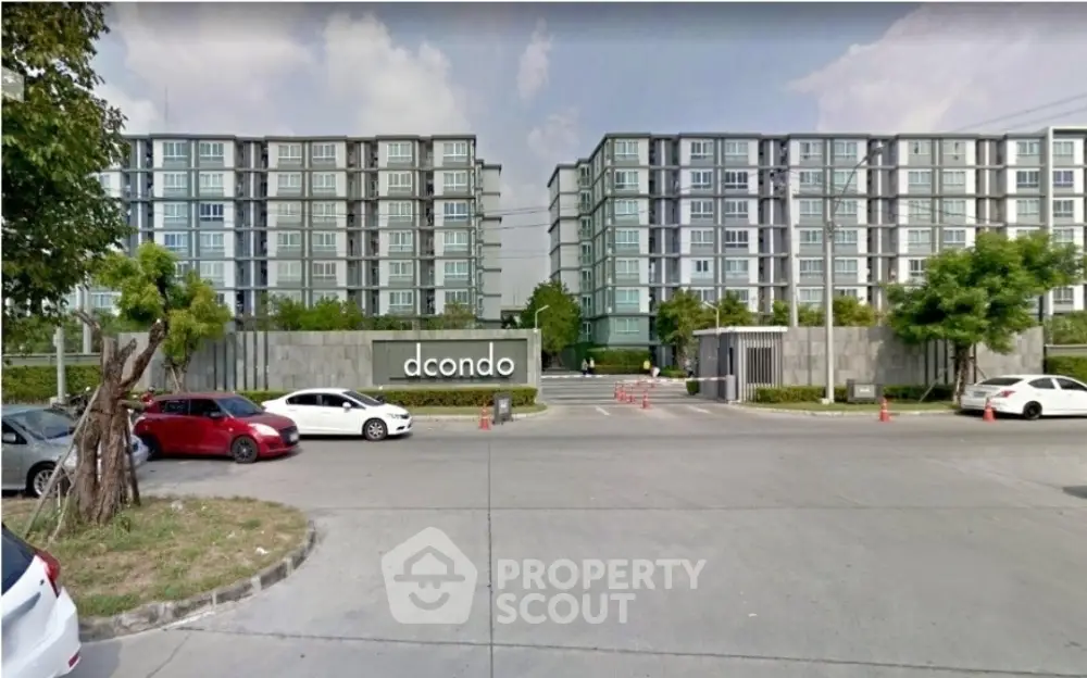 Modern condominium complex with spacious parking and lush greenery.