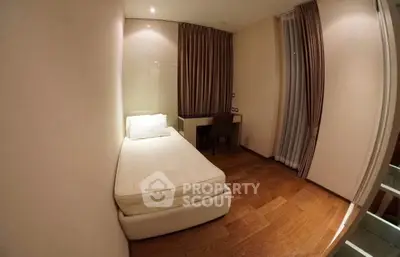 Cozy minimalist bedroom with single bed and wooden flooring