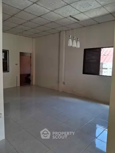 Spacious unfurnished room with tiled flooring and modern ceiling lights.