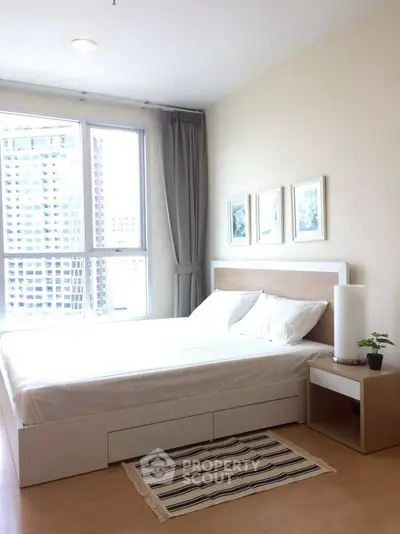 Bright and modern bedroom with large windows and stylish decor in urban apartment.