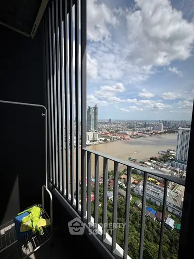 Stunning high-rise balcony view overlooking a vibrant cityscape and river, perfect for urban living.
