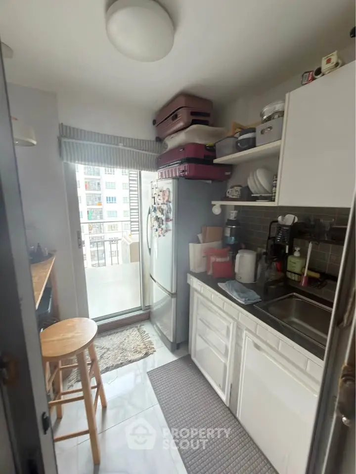 Cozy kitchen with modern appliances and balcony access in urban apartment