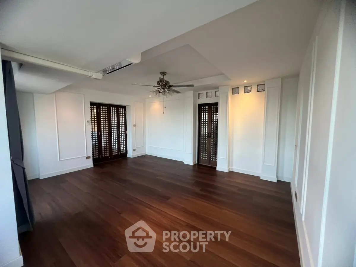 Spacious living room with elegant wooden flooring and ceiling fan