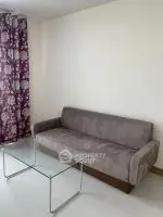 Cozy living room with modern sofa and glass coffee table, perfect for relaxation.
