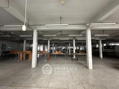 Spacious industrial interior with concrete floors and exposed beams, ideal for warehouse or manufacturing use.