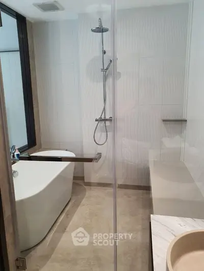 Modern bathroom with sleek shower and elegant bathtub design.