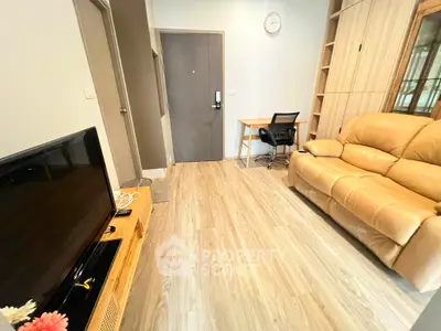 Cozy living room with modern decor, featuring a comfortable sofa, TV, and a small study area.