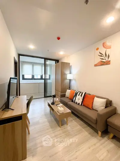Modern living room with stylish decor and natural light, featuring a cozy sofa and sleek wooden furniture.