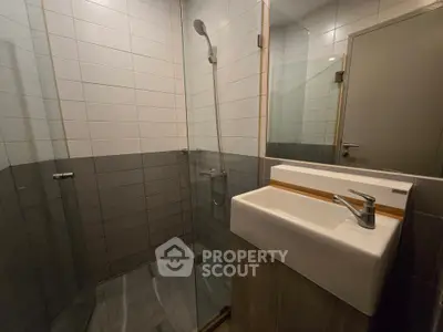 Modern bathroom with sleek shower and stylish sink in contemporary design.