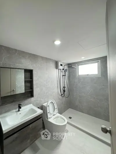 Modern bathroom with sleek design, featuring a shower and contemporary fixtures.