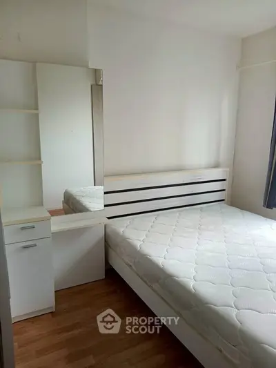 Cozy bedroom with modern furniture and ample natural light, perfect for relaxation and comfort.