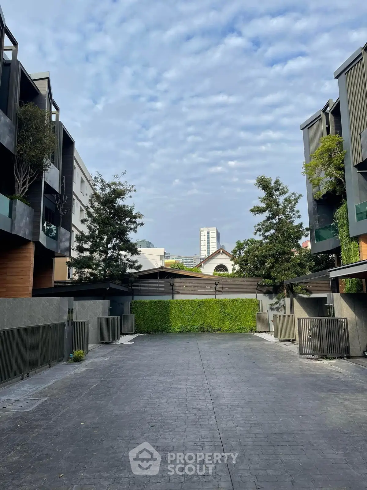 Modern townhouse complex with lush greenery and spacious driveway