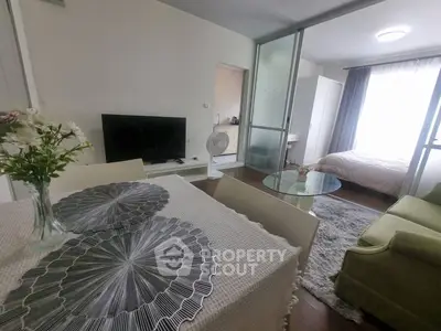 Modern open-plan living room with dining area and cozy bedroom in stylish apartment.