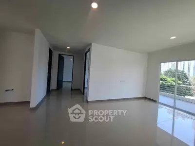 Spacious modern living room with large windows and glossy tiled floors