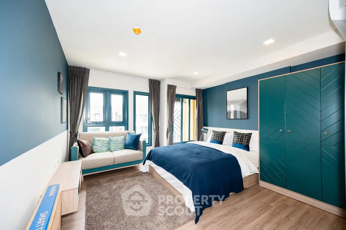 Modern bedroom with stylish decor, featuring a cozy bed, elegant wardrobe, and a comfortable seating area.