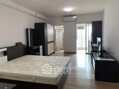 Spacious bedroom with balcony access in modern apartment
