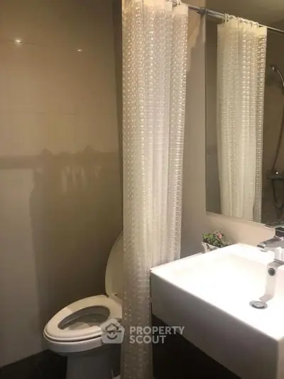 Modern bathroom with sleek fixtures and a shower curtain for privacy.