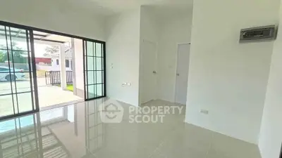 Spacious modern living room with glossy tile flooring and large sliding glass doors leading to outdoor area.