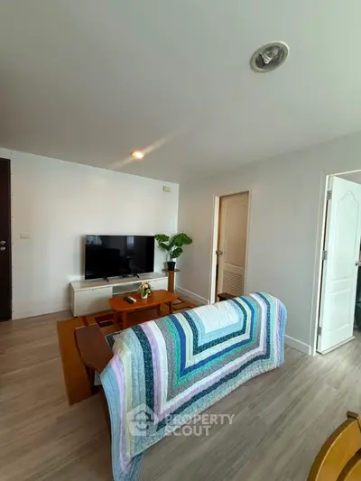 Cozy living room with modern decor and flat-screen TV, perfect for relaxation.