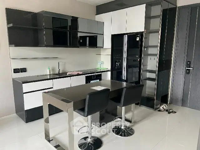 Modern kitchen with sleek black and white cabinetry and dining area
