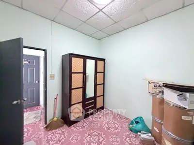Cozy storage room with wardrobe and patterned floor tiles in a residential unit.