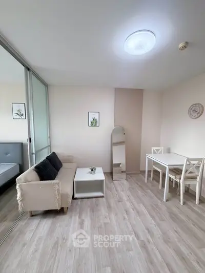 Modern living room with stylish decor and natural light, featuring a cozy sofa and dining area.