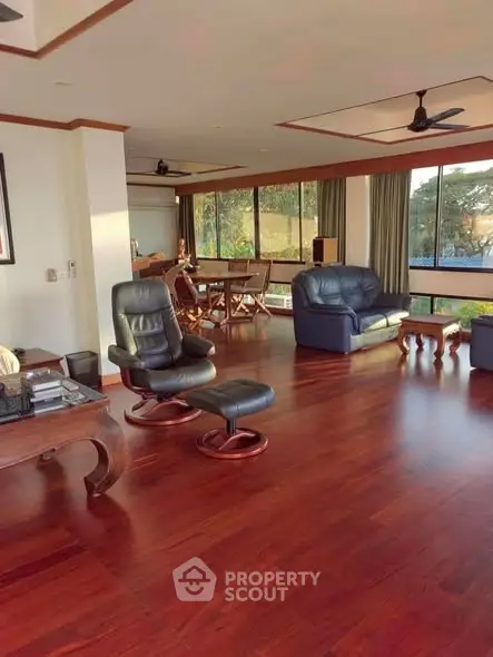 Spacious living room with hardwood floors and large windows offering natural light.